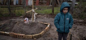 Фото мальчика у могилы мамы в Буче поразило мир: что известно о ребенке и его семье